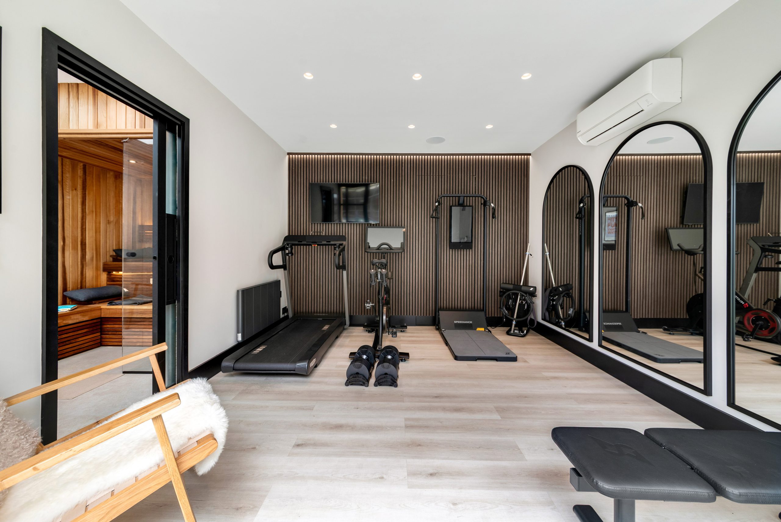 Garden gym interior with sauna visible through glass door