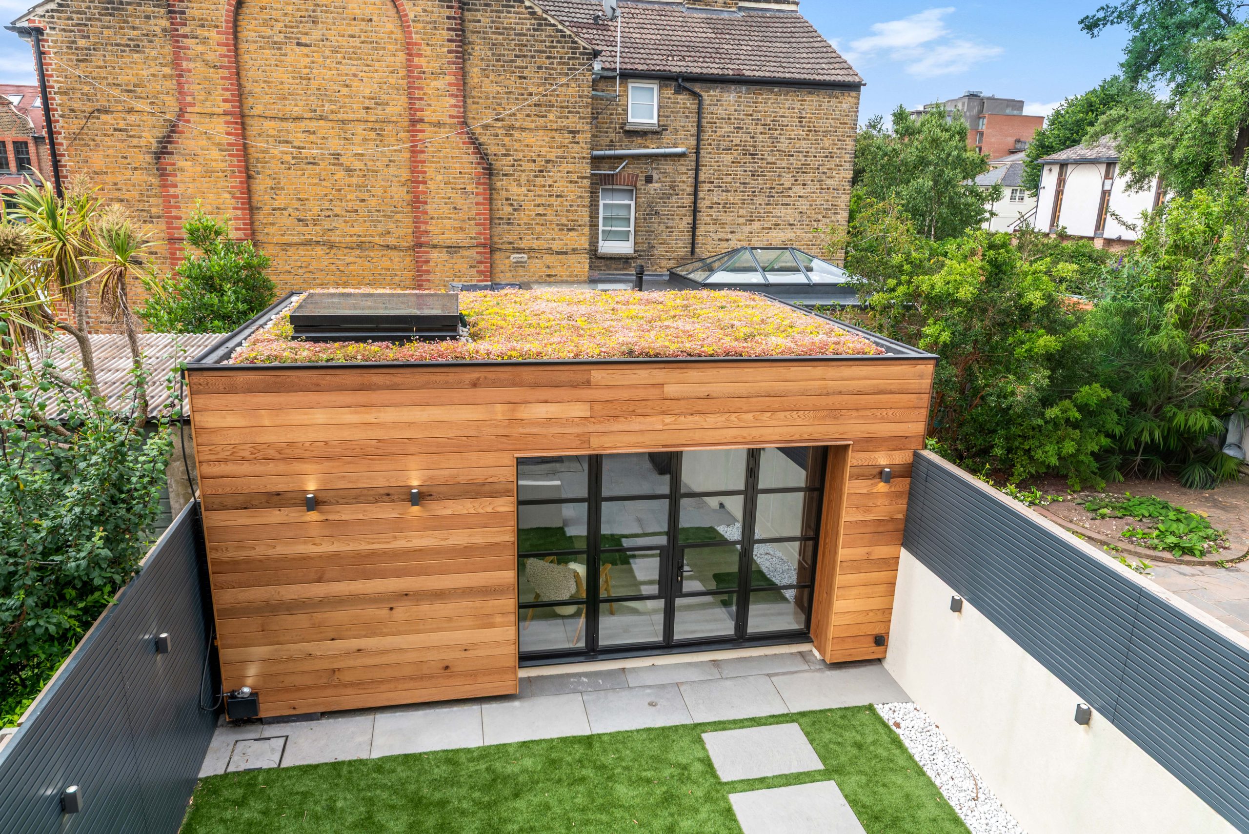 Modern garden gym with sedum roof and bifold doors